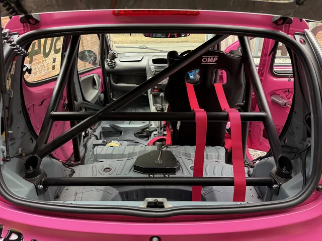 The stripped cabin of car 304, with its fitted roll cage and pink harness